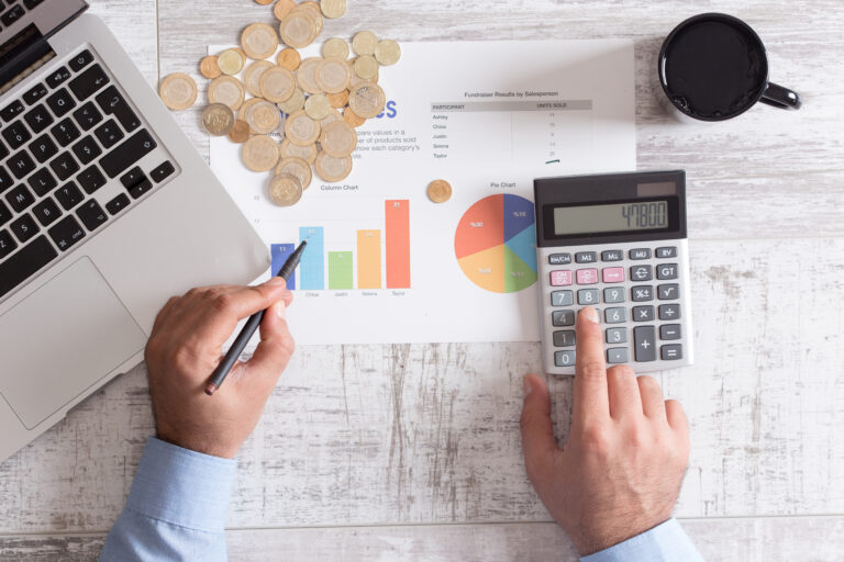 Man using a calculator to calculate the numbers on his desk